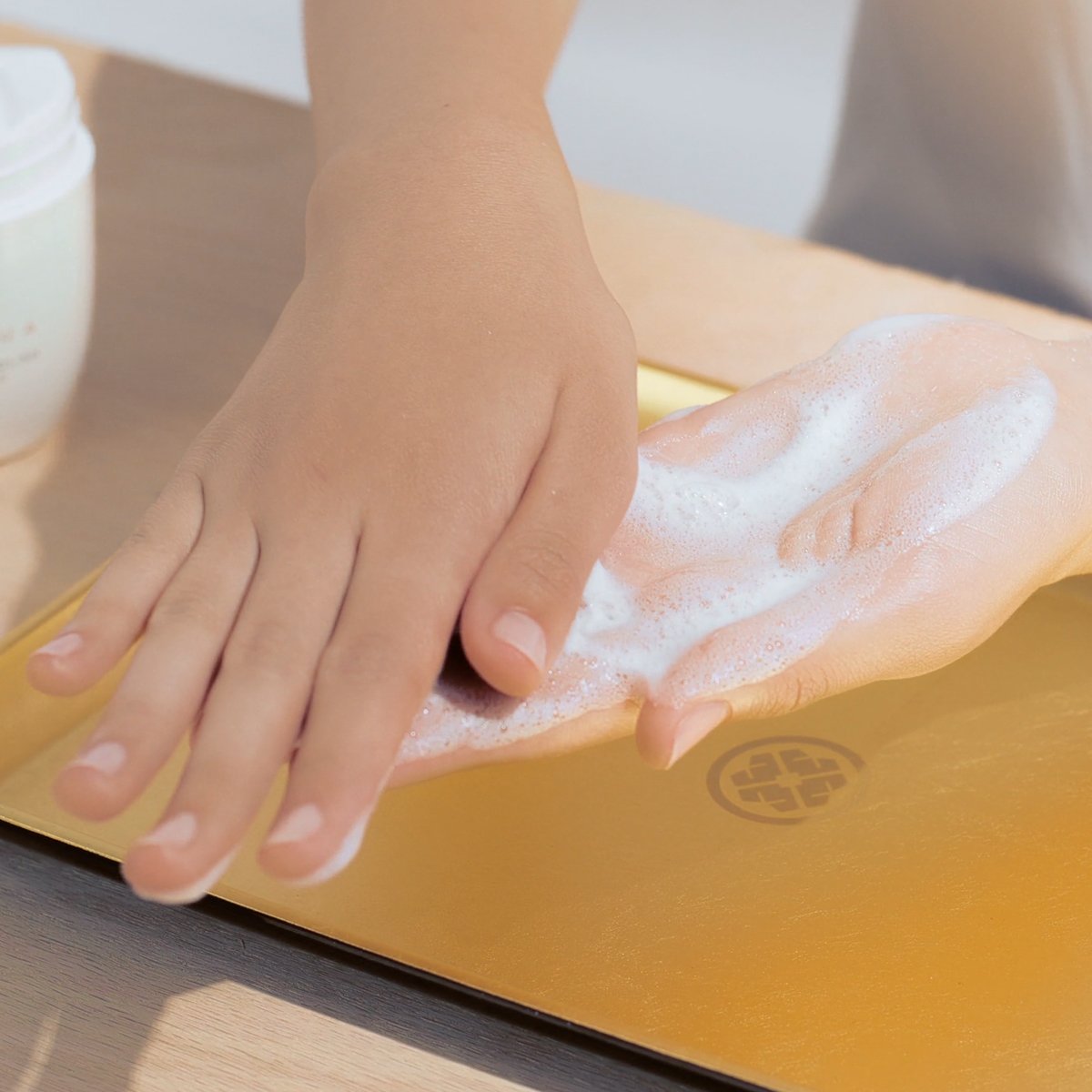 Model creating foam in hands with The Rice Polish and water before application.