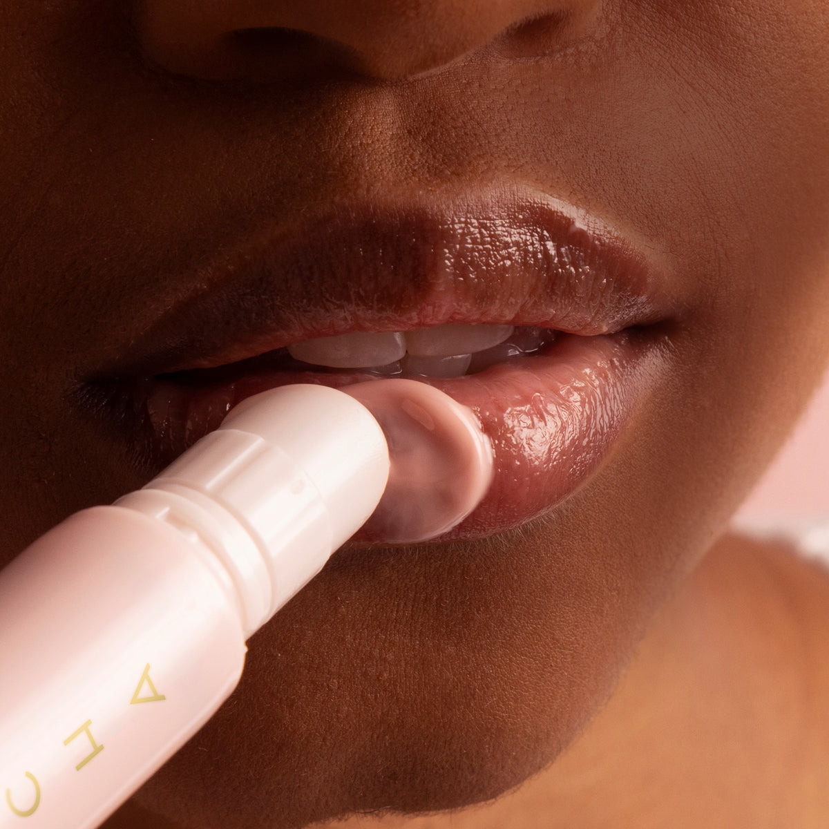 Model applying The Kissu Lip Treatment on lips.